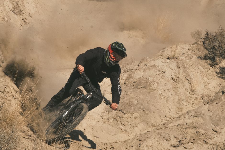 A mountain biker navigates a rocky trail in Kamloops, BC, Canada, creating a thrilling scene.
