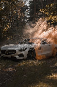 A luxury white Mercedes Benz parked in a misty forest with dramatic lighting effects.