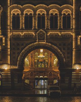 Night view of the illuminated facade of Moscow's iconic State Department Store, featuring ornate architecture.