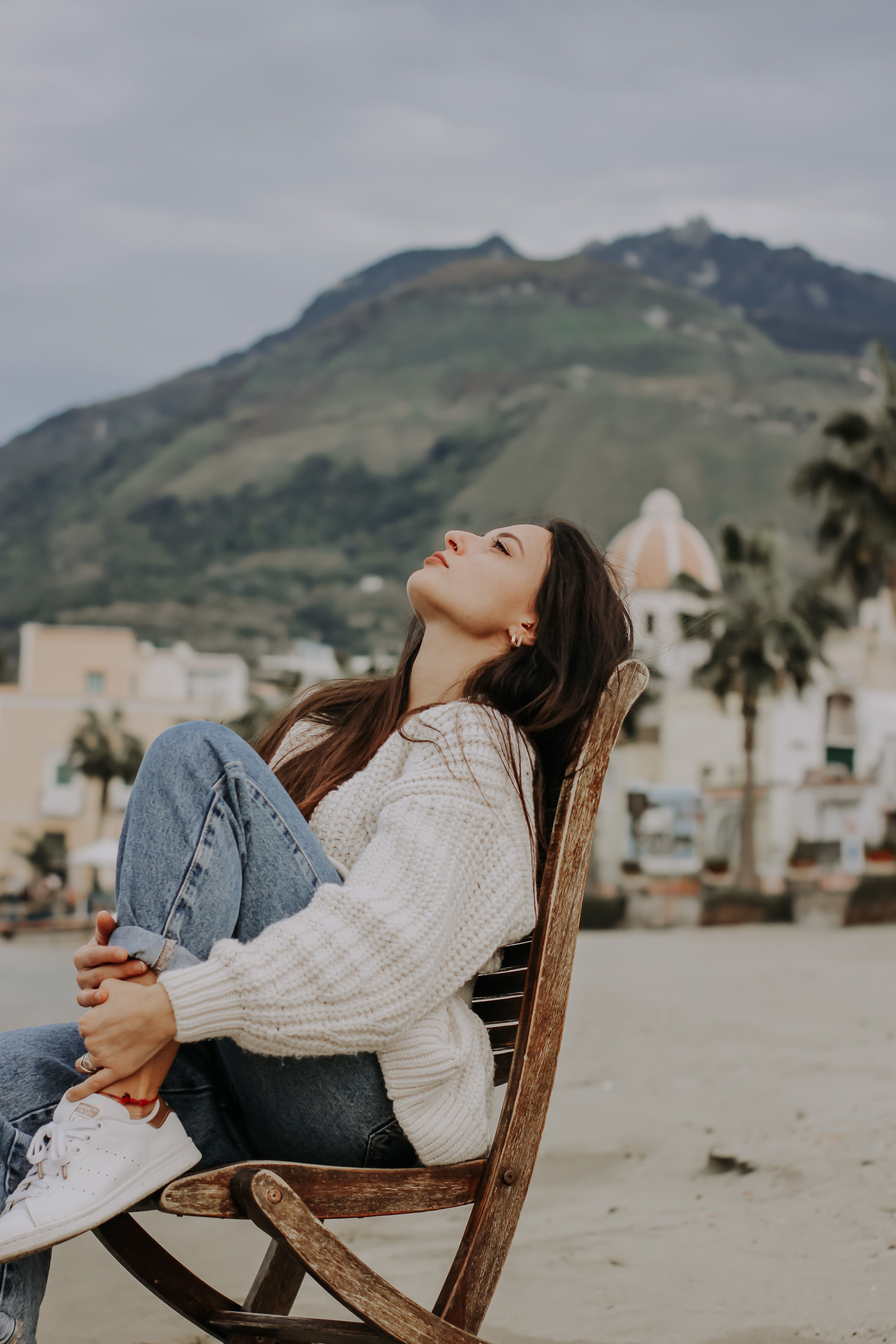 A Woman in a Sweater Sitting on a Chair · Free Stock Photo