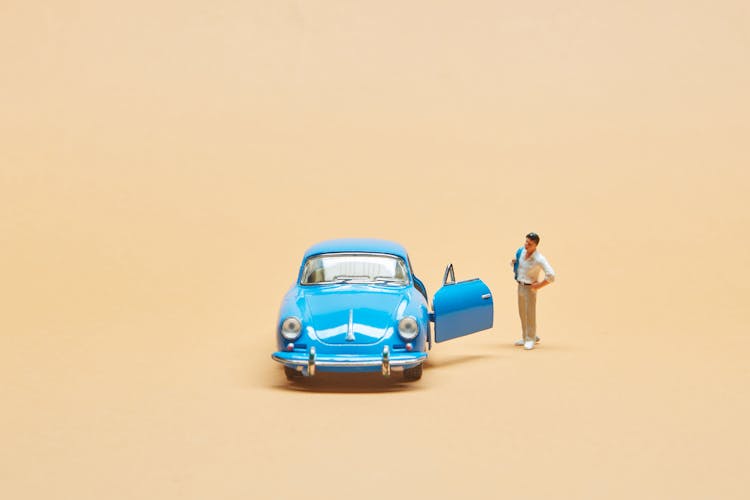 Miniature Car And A Human Figurine