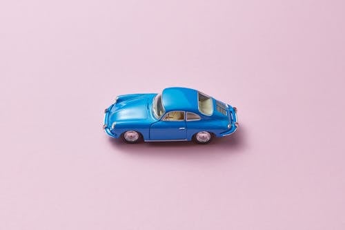A Blue Miniature Toy Car on Pink Background