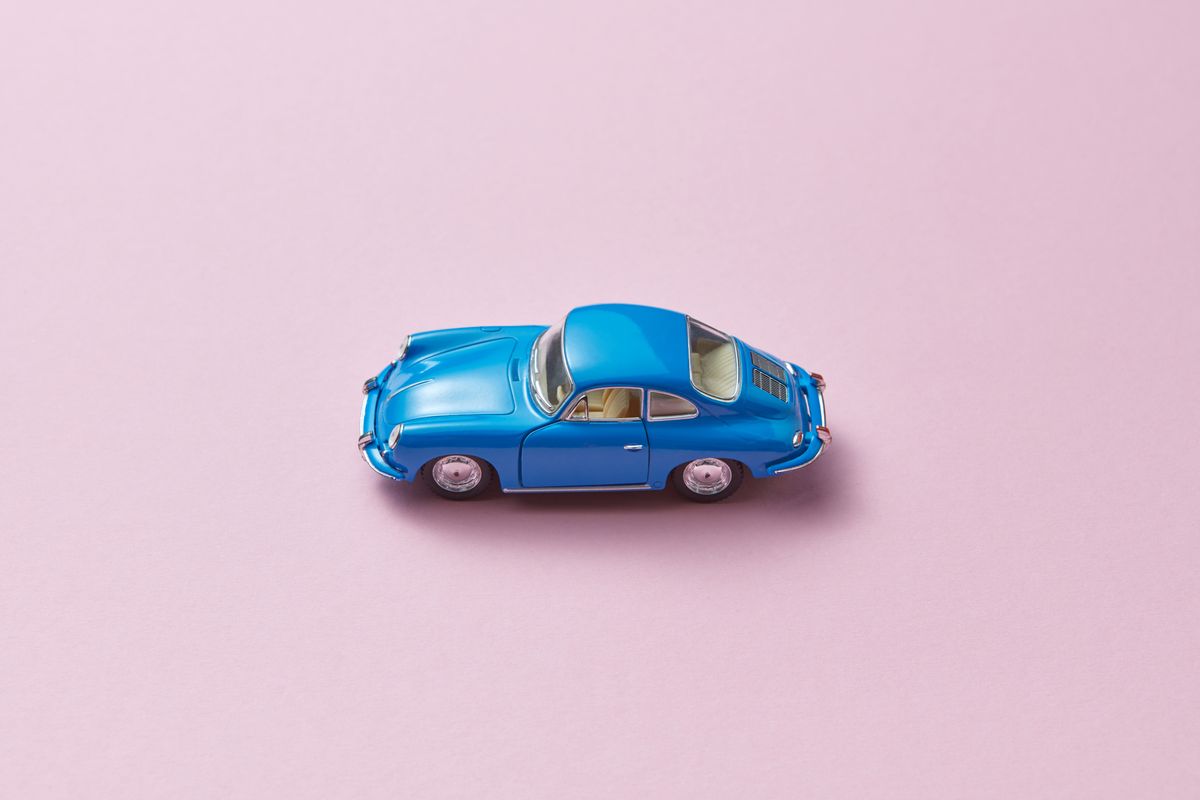 Carro retrô azul sobre fundo rosa