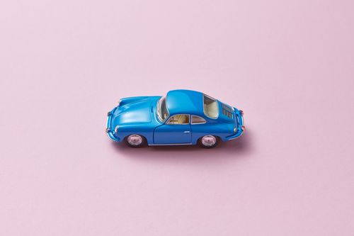 Free High-angle view of a blue retro toy car on a pink background. Stock Photo