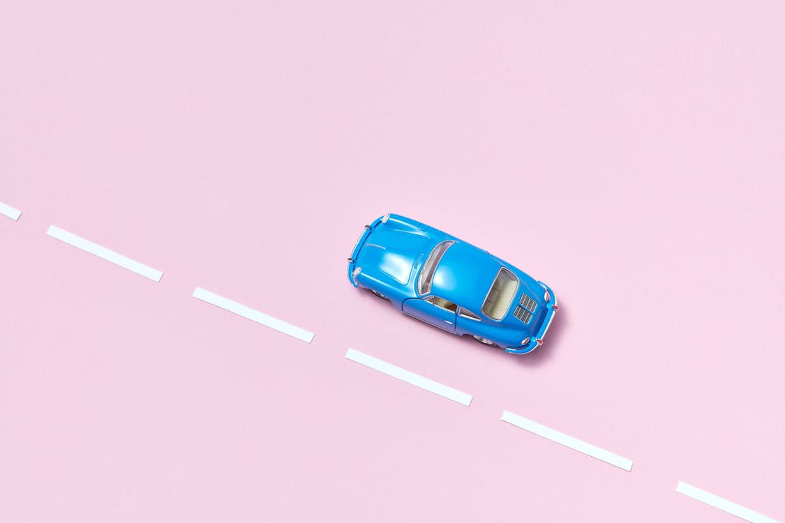 Photo of a Blue Toy Car on a Pink Surface
