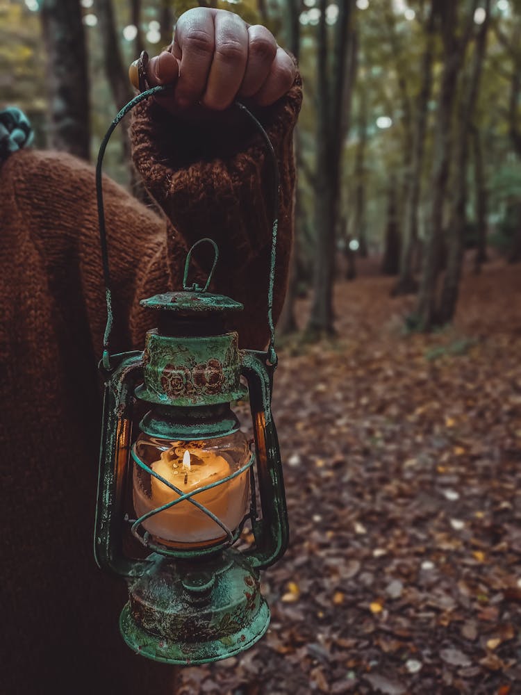 Person Holding A Lantern With A Lit Candle 