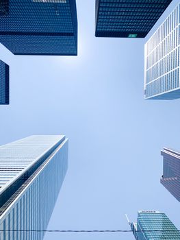 Low-angle view of Toronto skyscrapers against a bright blue sky, showcasing modern urban architecture.
