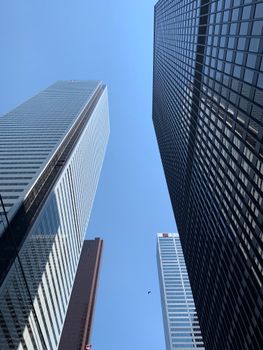 Low angle view of skyscrapers in Toronto's financial district against a clear blue sky.