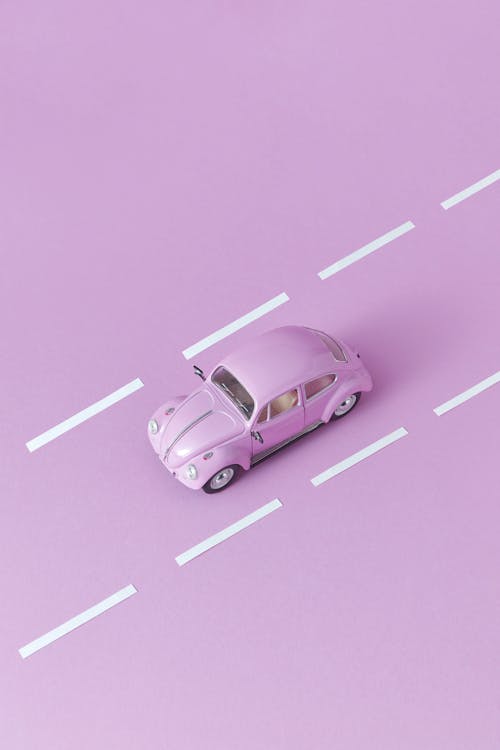 Photo of a Pink Miniature Car Near White Lines