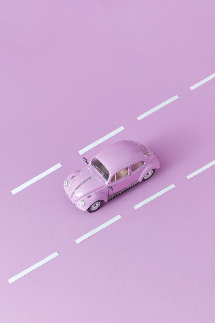 Photo Of A Pink Miniature Car Near White Lines