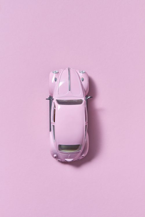 Free Top view of a pink toy car on a matching pink background, creating a minimalist look. Stock Photo