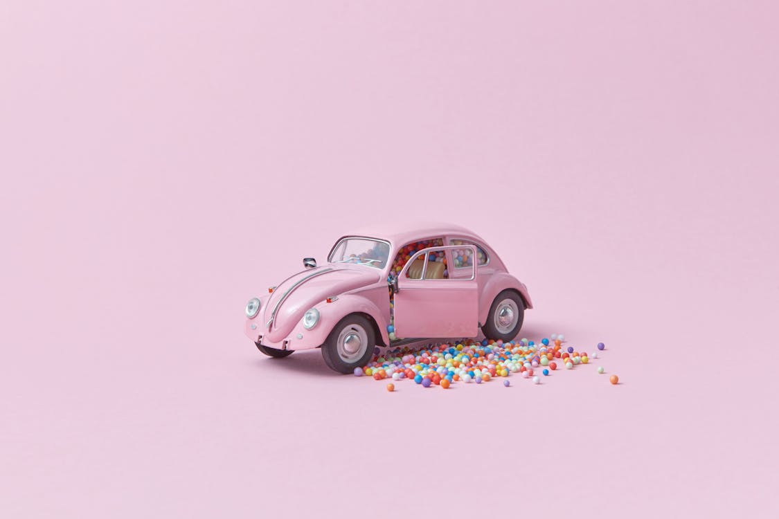 A Pink Toy Car with Colorful Beads on Pink Surface