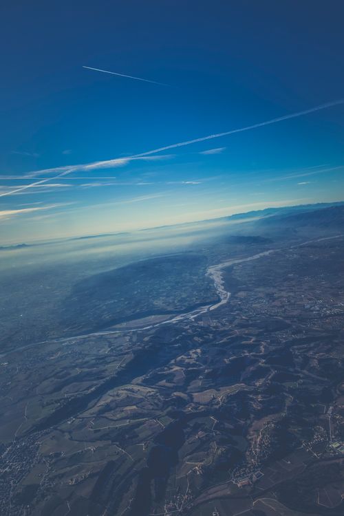 Free A breathtaking aerial view showcasing a serene landscape with mountains, sky, and river. Stock Photo