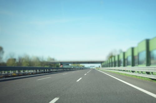 青い空の下の灰色のアスファルト道路