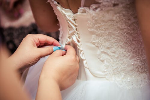 бесплатная Фотография женщины, поправляющей свадебное платье Стоковое фото