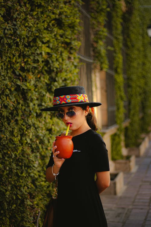 A Woman in Black Shirt Wearing Black Hat