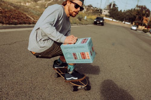 Man Skateboarding with Box on Street