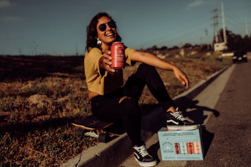 Free A Woman Holding a Can of Beer Stock Photo
