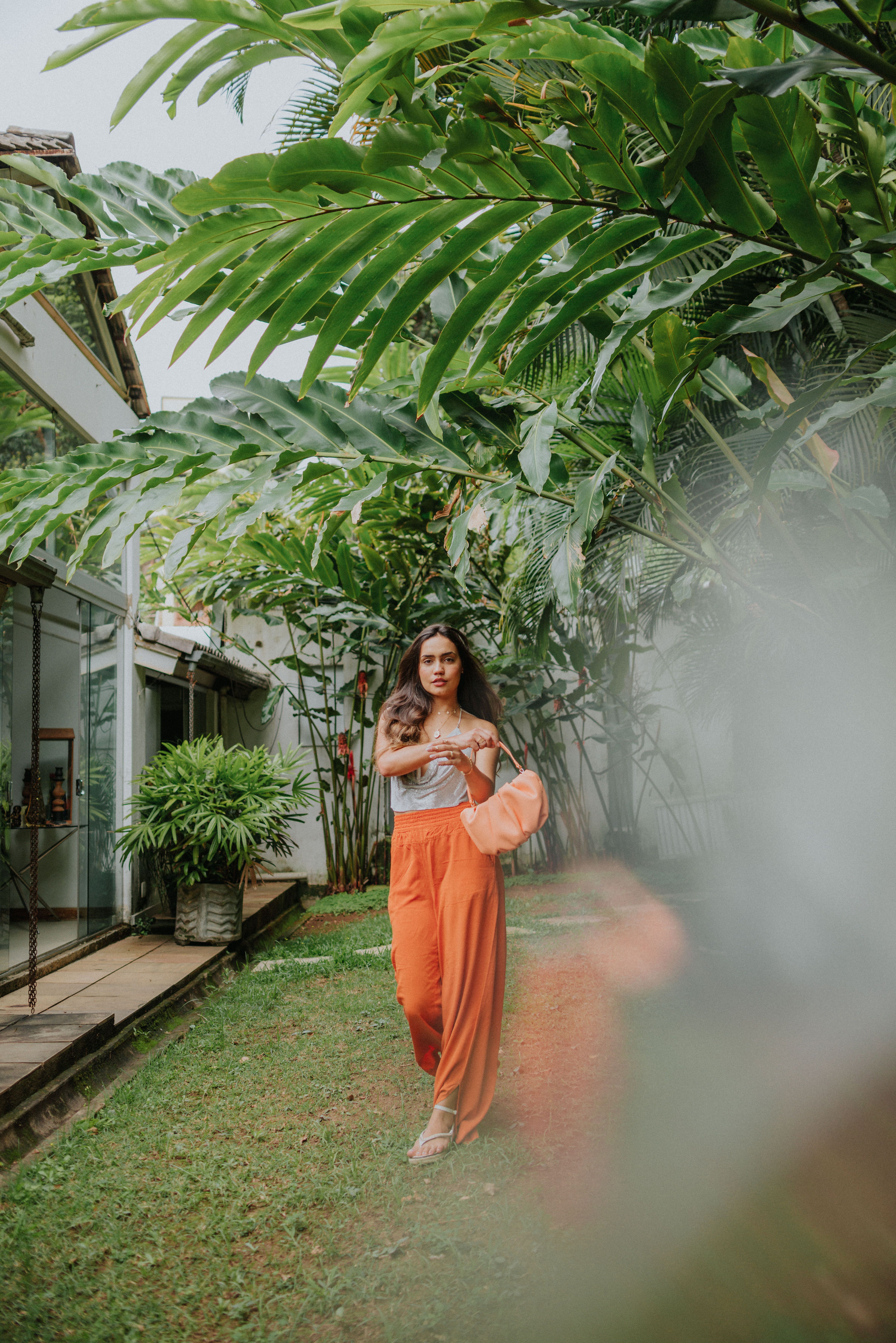 woman in orange pants standing on green grass