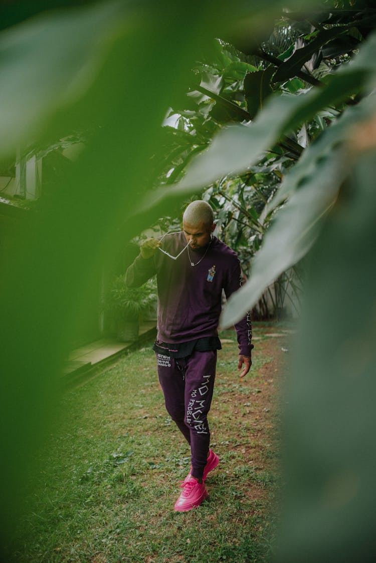 
A Man In A Purple Sweatsuit Wearing Sunglasses