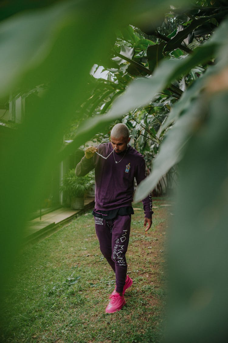 
A Man In A Purple Sweatsuit Wearing Sunglasses