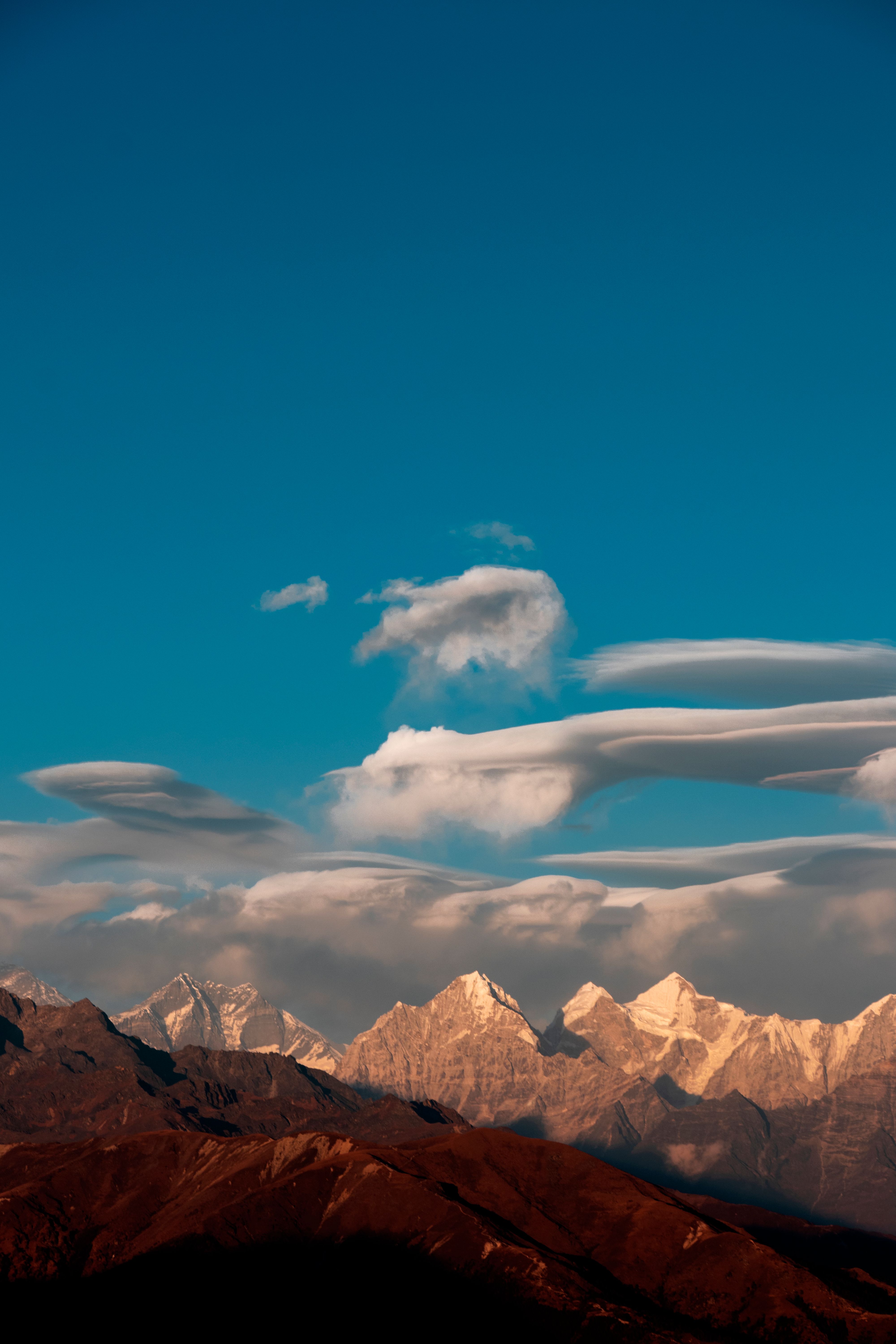 Breathtaking view of the Himalayan mountains in Nepal under a vibrant blue sky with scenic clouds.