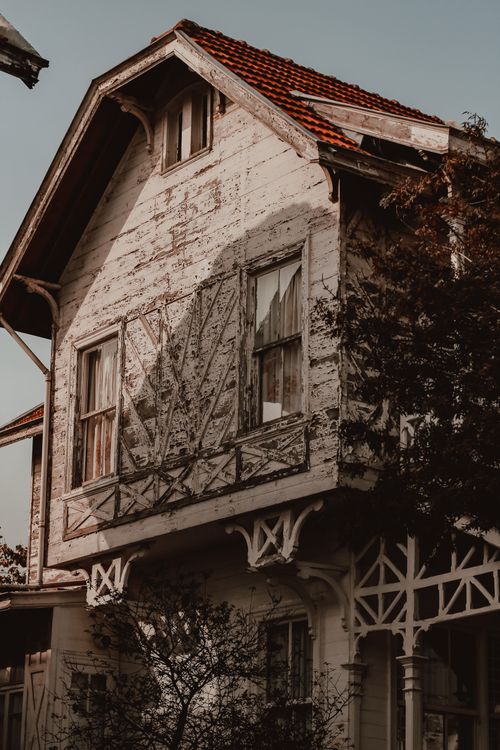 Free A weathered wooden house with intricate designs in İstanbul, surrounded by plants, capturing a vintage aesthetic. Stock Photo
