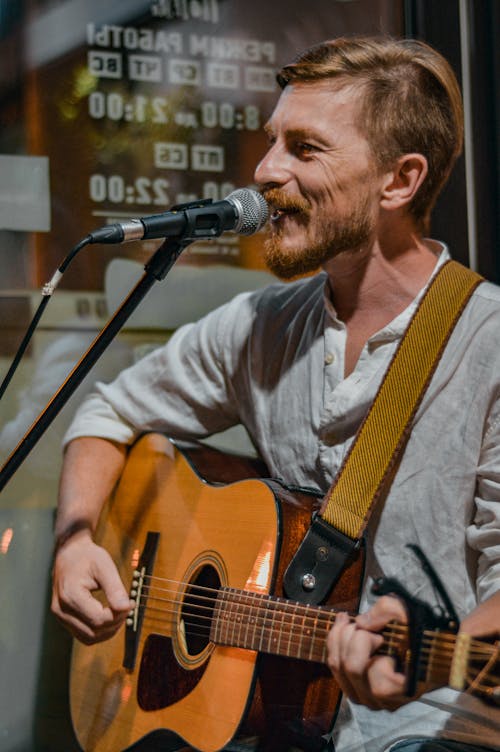 Man Playing Guitar While Singing