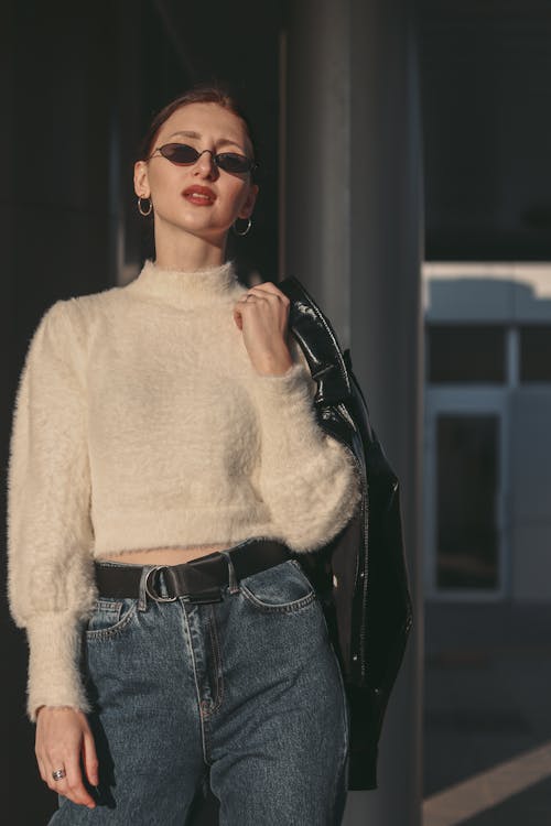 Woman Wearing Sunglasses Holding Leather Jacket