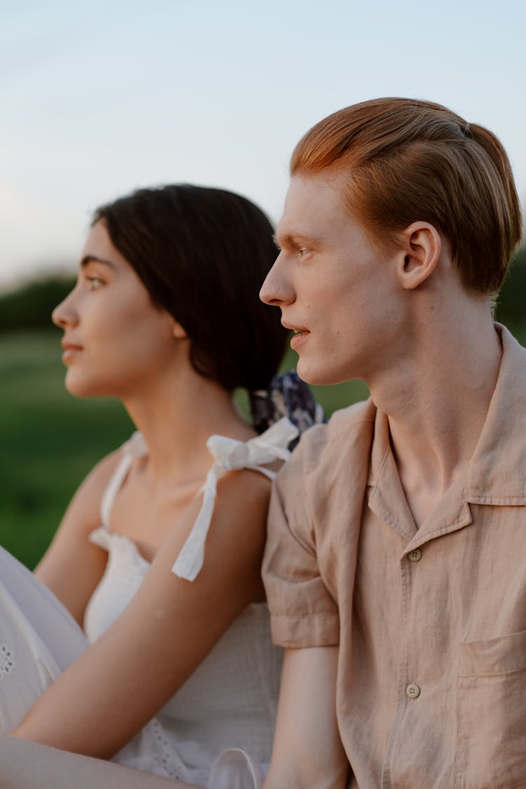 Young Couple Sitting And Looking At Sunset