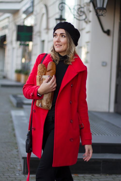 Free A fashionable woman in a red coat walks in Kaliningrad holding bread. Stock Photo