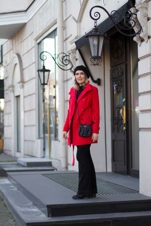 Free Stylish woman in a red coat standing on an urban street, exuding elegant fashion. Stock Photo