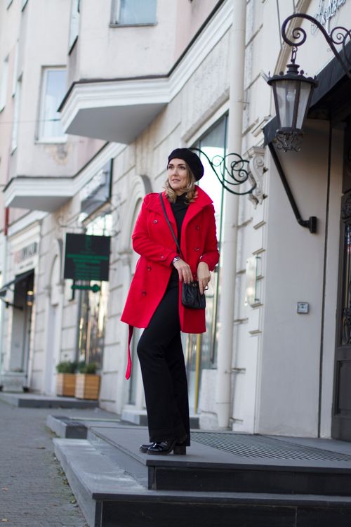 Free Chic woman in a vibrant red coat confidently poses on a city street, showcasing modern fashion. Stock Photo