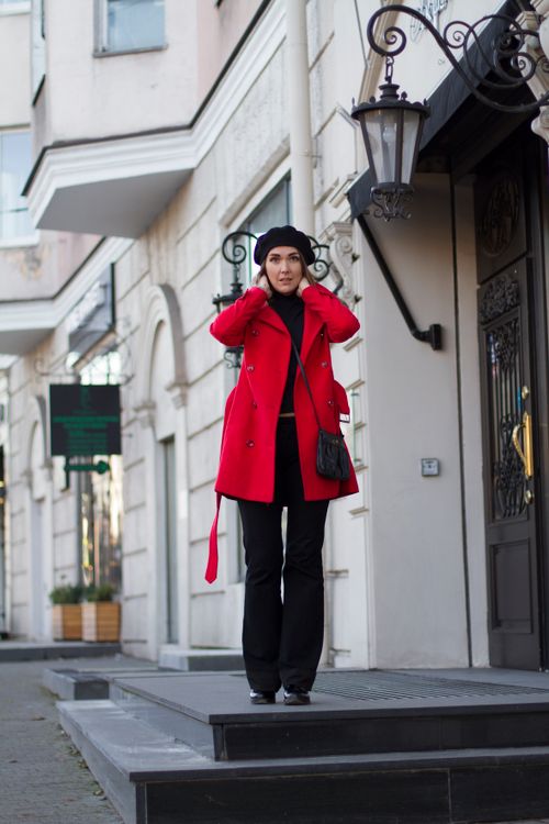 Free Stylish woman in red coat standing on city street, exuding confidence and elegance. Stock Photo