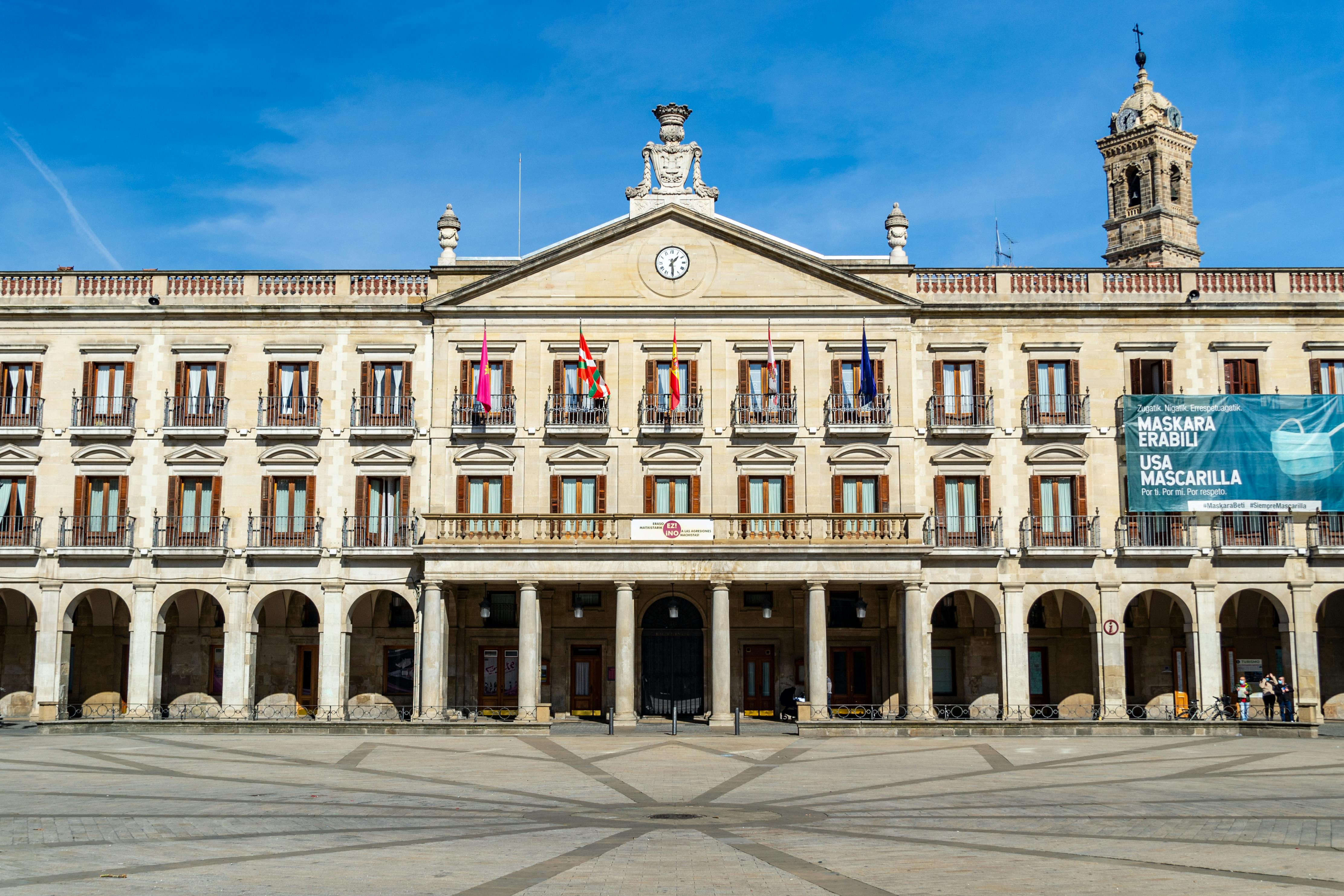 Front view of the historic facade of Vitoria-Gasteiz City Hall, Spain, with a clear blue sky.