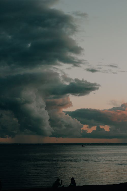 Silhouette of People Sitting on the Shore