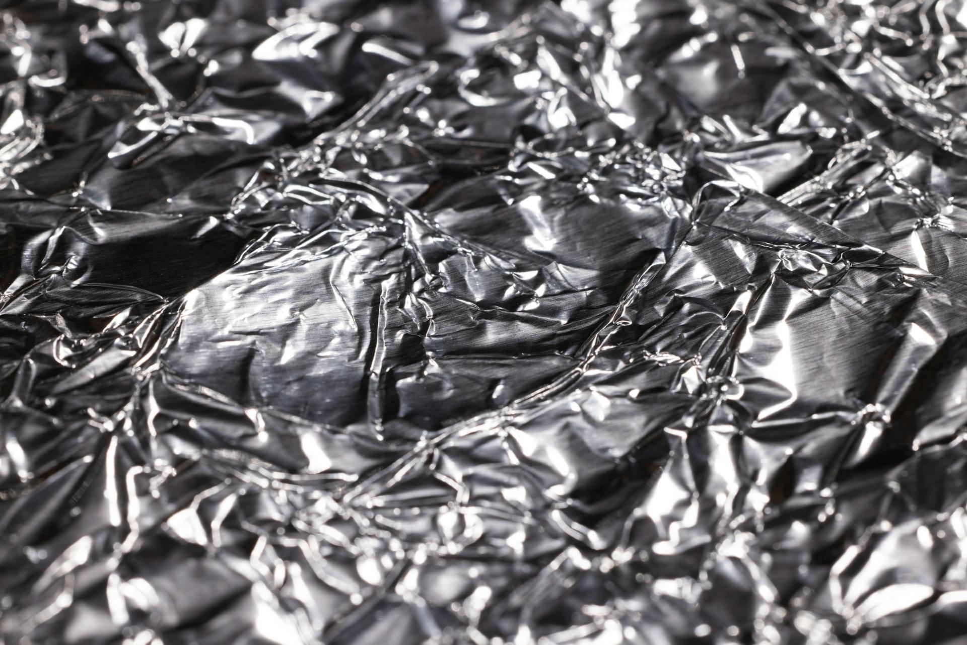 Abstract close-up of shiny crumpled aluminum foil surface texture.