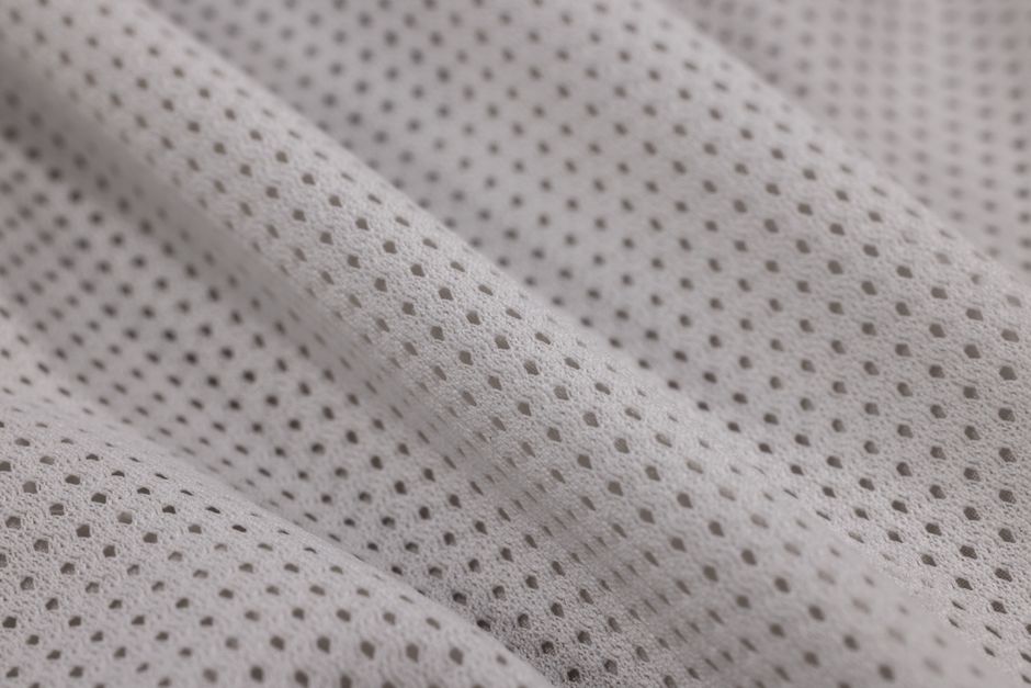 Close-up of breathable fabric texture showing moisture-wicking pores - comfortable lightweight travel clothes Close-up of breathable fabric texture showing moisture-wicking pores - comfortable lightweight travel clothes