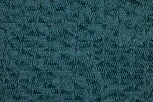 High-resolution close-up of teal textured knitted fabric featuring a chevron pattern, perfect for backgrounds.