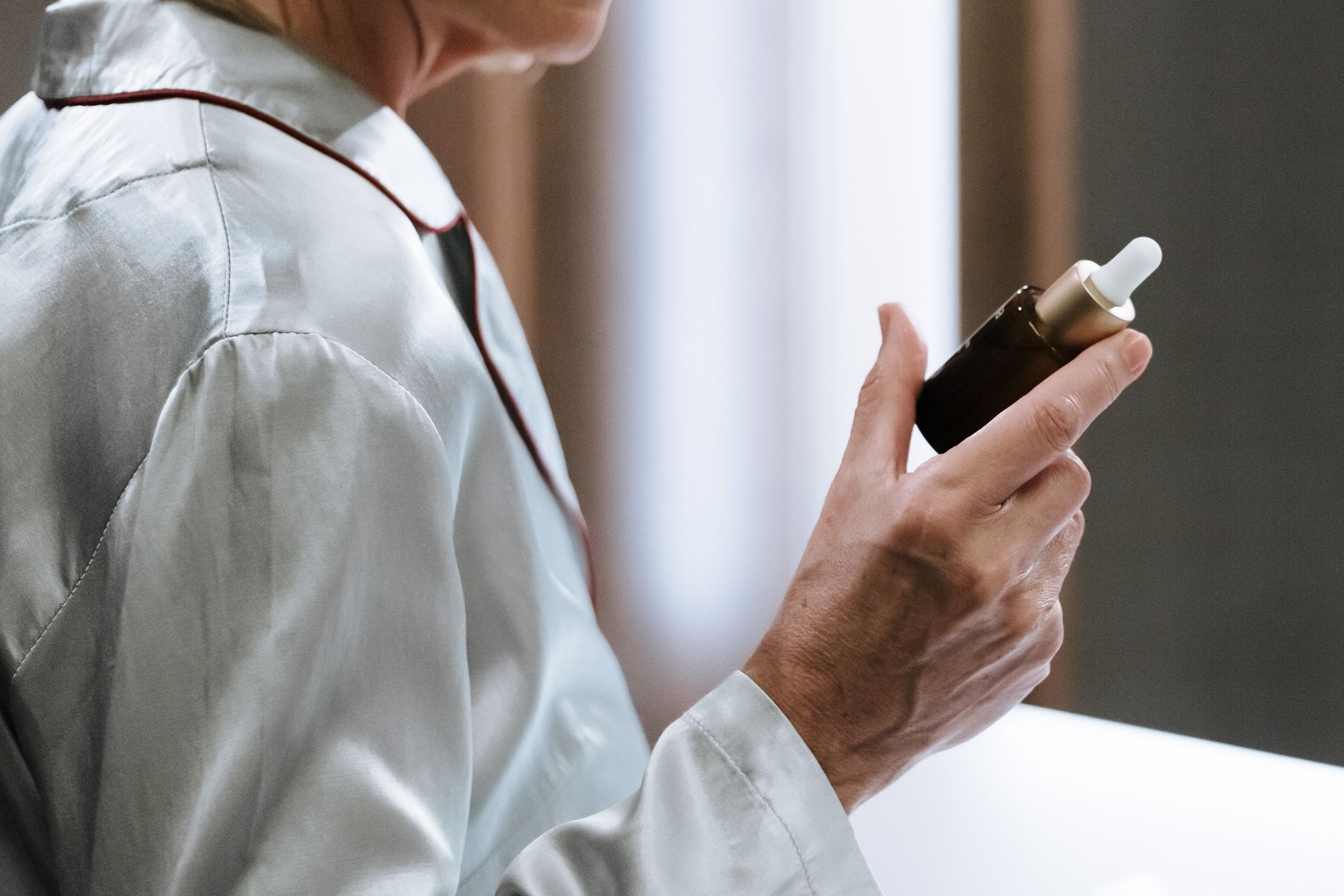 Discover the Best Peptides for Anti-Aging in the US 1 Close-up of a person holding a serum dropper bottle, highlighting skincare routine and self-care.