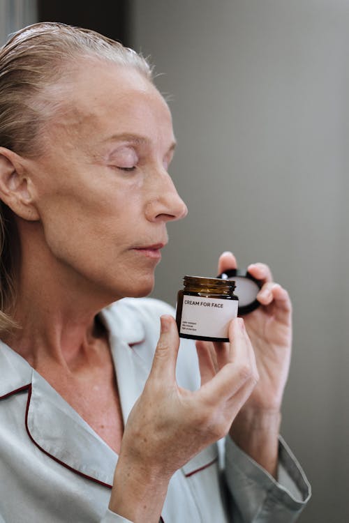 Woman Smelling Cosmetic Product