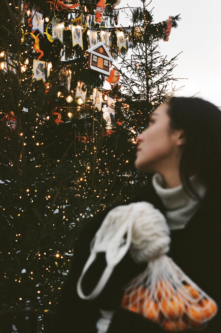 Woman Looking Back At A Christmas Tree