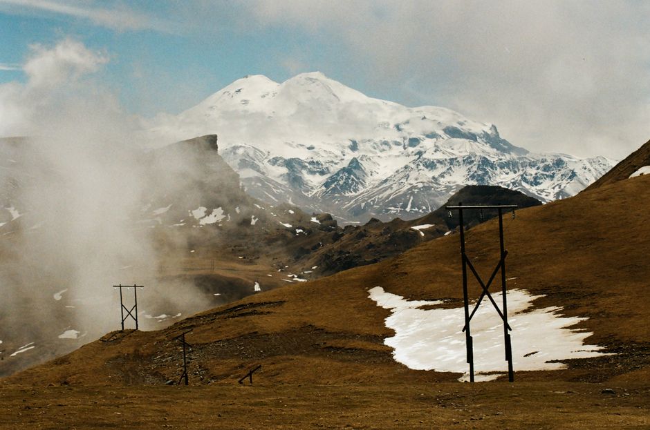 Breathtaking mountain landscape with snowcaps and power lines, revealing serene natural beauty.