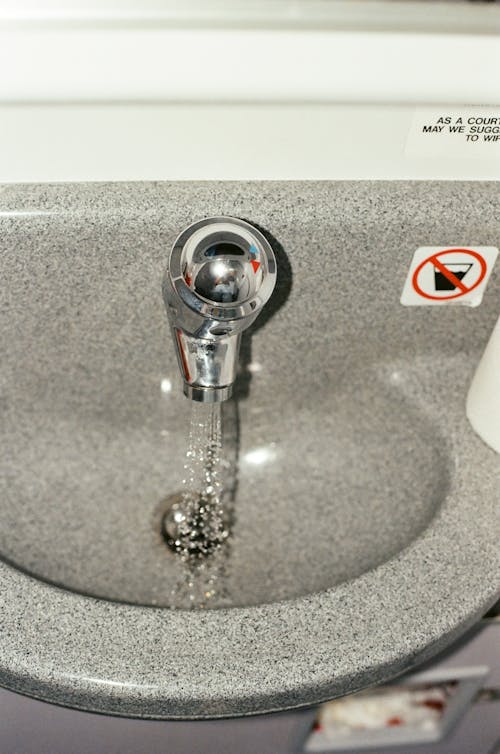 Free Running Water on Stainless Steel Faucet Stock Photo