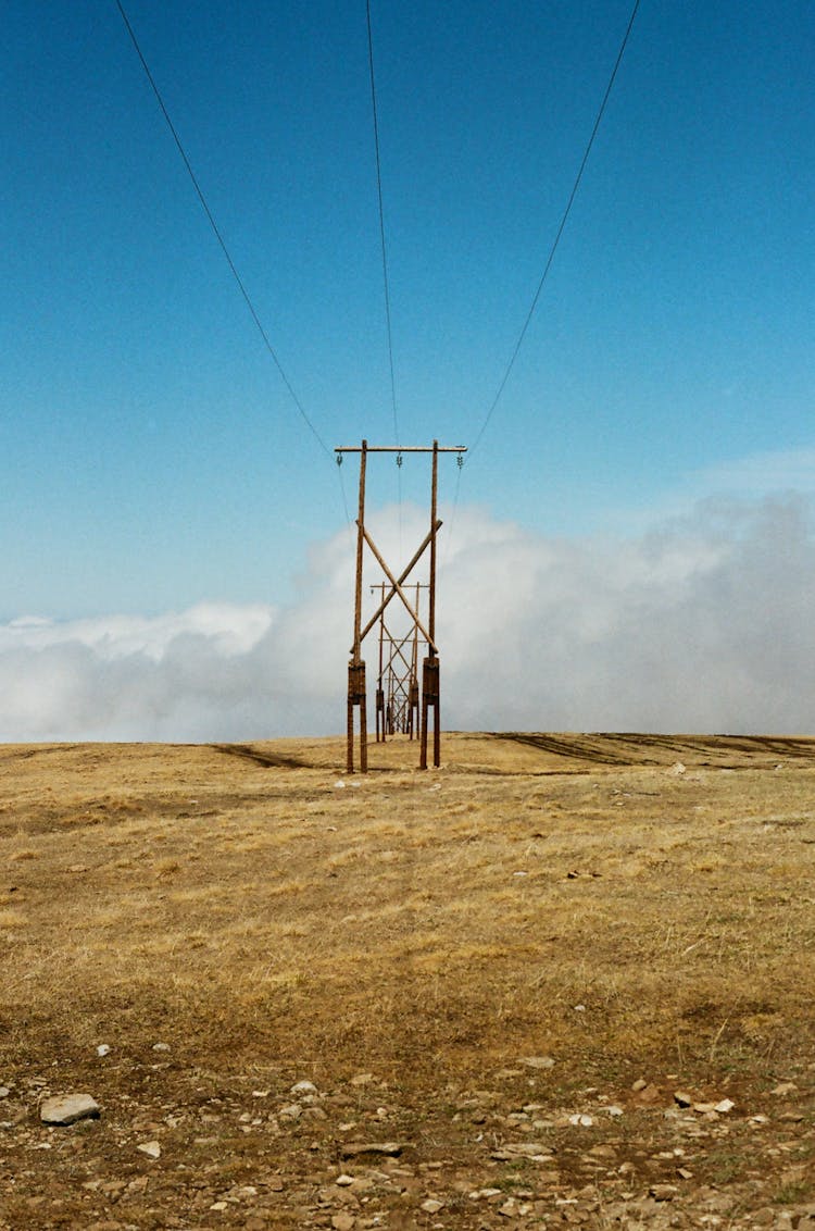 Electricity Poles And Lines On A Field 