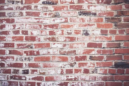Free Detailed texture of a weathered red brick wall perfect for use as a background or wallpaper. Stock Photo