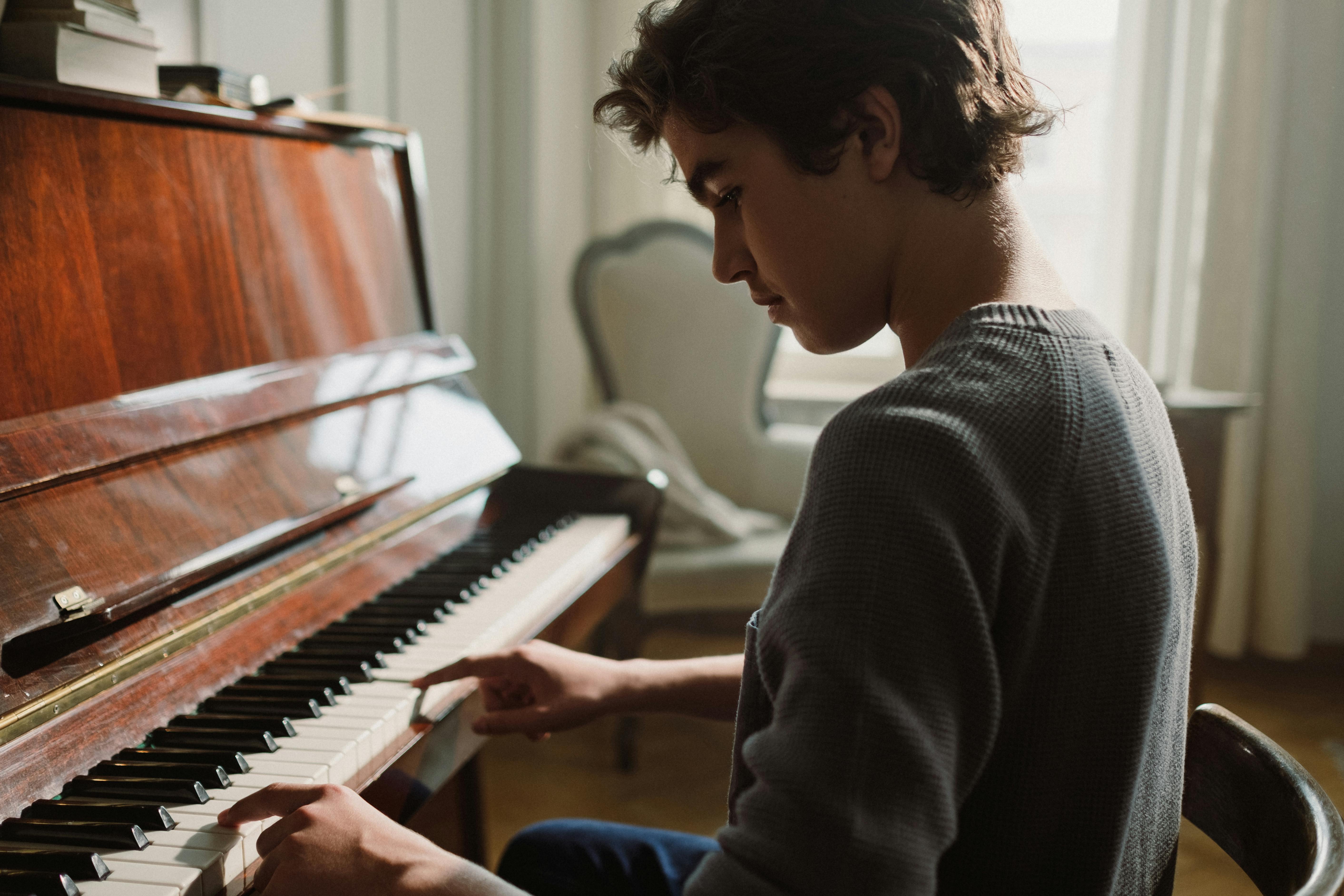 Gut aussehender Junge spielt Klavier · KostenlosGut aussehender Junge spielt Klavier · Kostenlos  