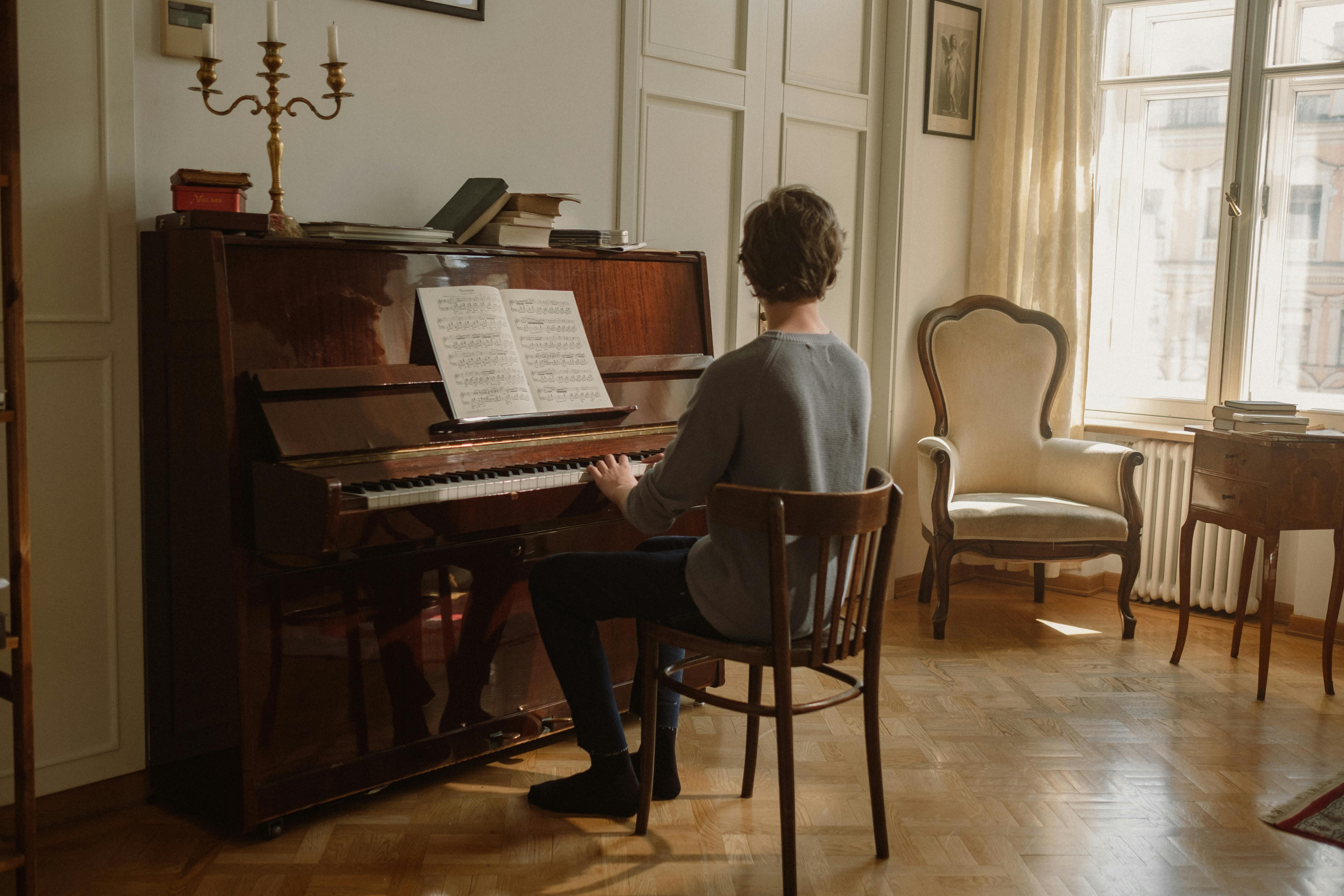 Anak Laki-Laki Duduk di Kursi Memainkan PianoAnak Laki-Laki Duduk di Kursi Memainkan Piano  