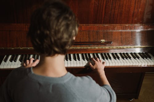 Person Playing a Wooden Piano