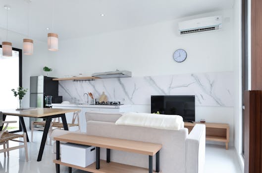 Stylish minimalist apartment kitchen and living room interior with modern furnishings.